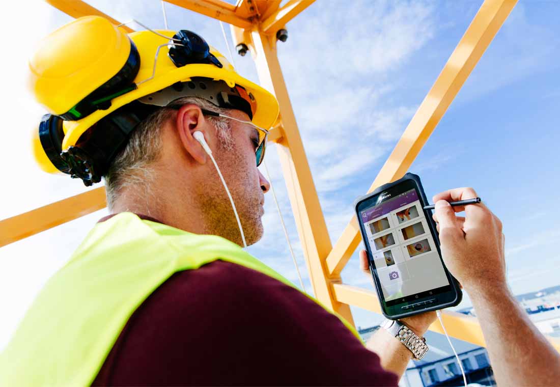 Prüfer mit Tablet auf Baustelle